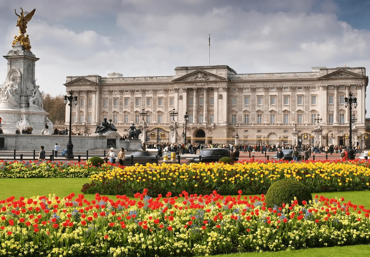 Buckingham Palace behind colourful flower beds and the Victoria Memorial